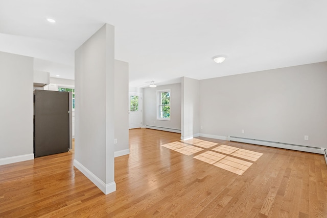 15 Essex St, Westbrook, ME 04092 - empty room with baseboard heating, light wood-type flooring, a baseboard heating unit, and baseboards
