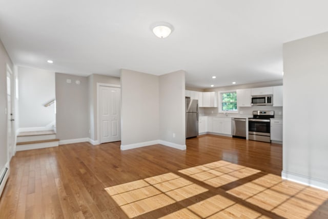 15 Essex St, Westbrook, ME 04092 - unfurnished living room with light wood-type flooring, recessed lighting, baseboards, stairway, and a baseboard heating unit