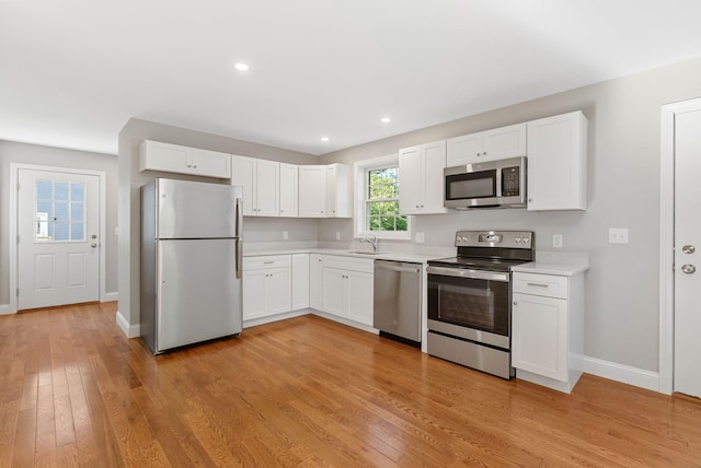 15 Essex St, Westbrook, ME 04092 - kitchen with stainless steel appliances, a sink, light countertops, baseboards, and light wood-style flooring