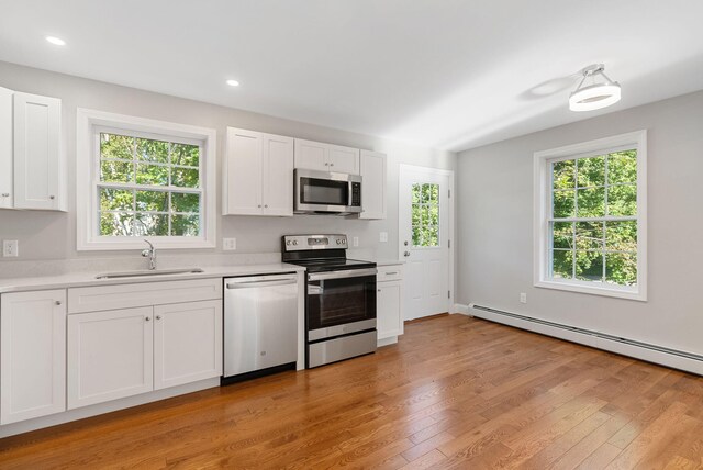 15 Essex St, Westbrook, ME 04092 - kitchen featuring stainless steel appliances, a sink, light countertops, white cabinetry, and light wood finished floors