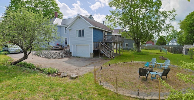 129 Libby St, Pittsfield, ME 04967 - back of house with stairway, concrete driveway, a wooden deck, an attached garage, and a chimney