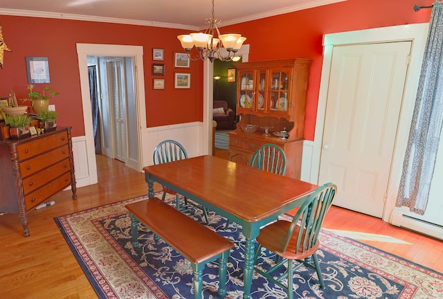 129 Libby St, Pittsfield, ME 04967 - dining room with a chandelier, light wood finished floors, wainscoting, and crown molding