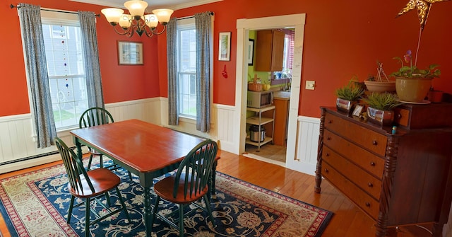 129 Libby St, Pittsfield, ME 04967 - dining room with a wainscoted wall, healthy amount of natural light, hardwood / wood-style flooring, a chandelier, and crown molding