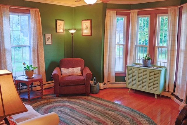 129 Libby St, Pittsfield, ME 04967 - sitting room featuring wood finished floors, ornamental molding, plenty of natural light, a baseboard heating unit, and a ceiling fan