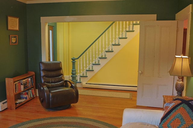 129 Libby St, Pittsfield, ME 04967 - living area featuring a baseboard heating unit, wood finished floors, stairway, and ornamental molding