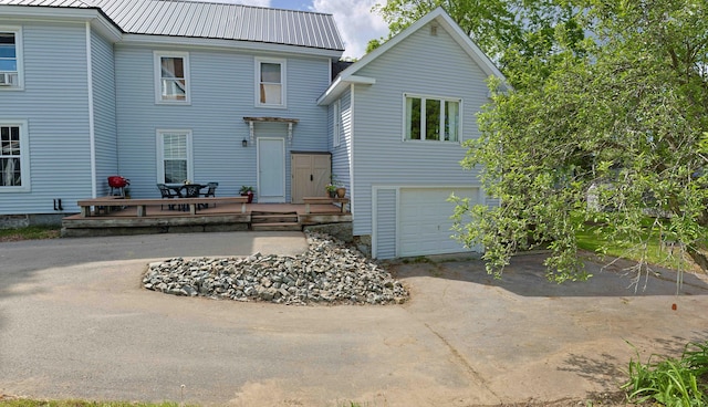 129 Libby St, Pittsfield, ME 04967 - back of property featuring driveway, an attached garage, and metal roof
