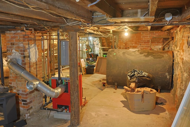 129 Libby St, Pittsfield, ME 04967 - unfinished below grade area with heating fuel, a wood stove, and brick wall