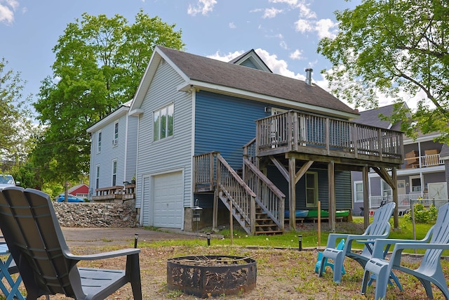 129 Libby St, Pittsfield, ME 04967 - rear view of property featuring a fire pit, a wooden deck, a garage, stairway, and driveway