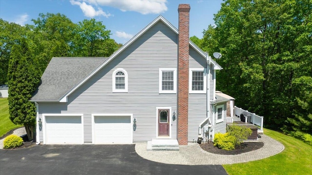 59 Sanderson Rd, Poland, ME 04274 - view of side of home featuring driveway, a chimney, and a garage