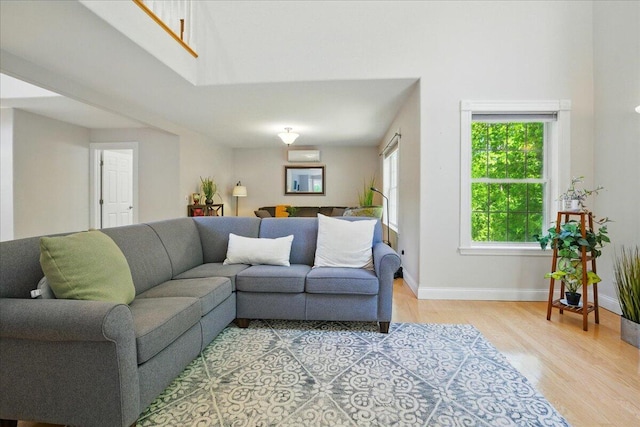 59 Sanderson Rd, Poland, ME 04274 - living area with light wood finished floors, baseboards, a high ceiling, and a wall unit AC