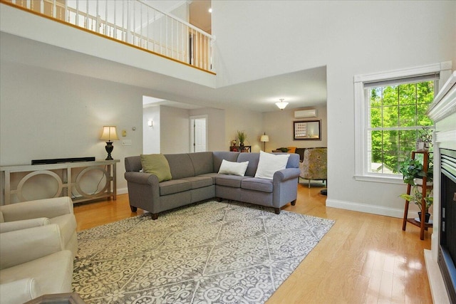 59 Sanderson Rd, Poland, ME 04274 - living area with a high ceiling, wood finished floors, baseboards, and a wall mounted air conditioner