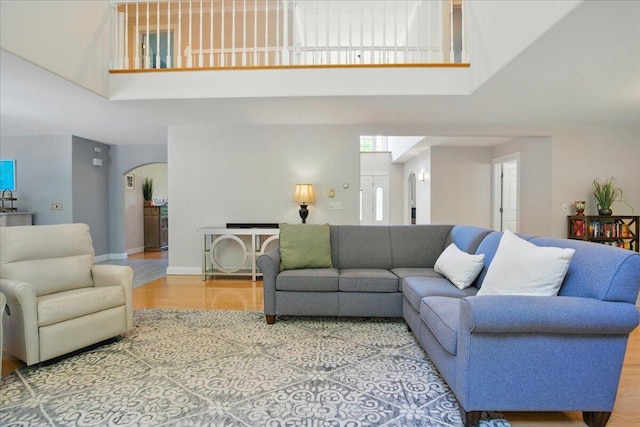 59 Sanderson Rd, Poland, ME 04274 - living room featuring a high ceiling, arched walkways, light wood-type flooring, and baseboards