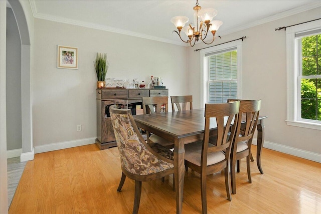 59 Sanderson Rd, Poland, ME 04274 - dining area with light wood-style flooring, baseboards, a chandelier, crown molding, and arched walkways