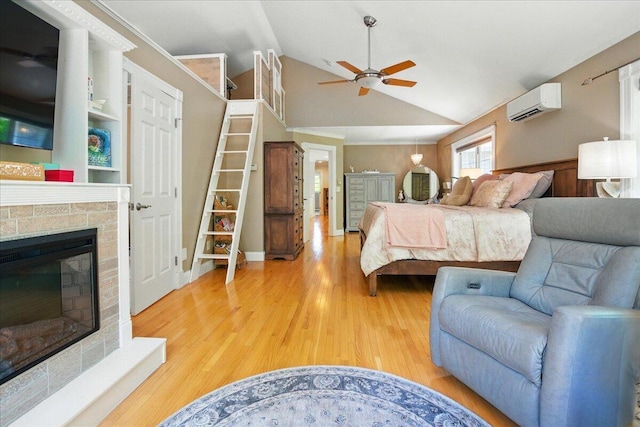 59 Sanderson Rd, Poland, ME 04274 - bedroom featuring a wall unit AC, lofted ceiling, light wood finished floors, and a glass covered fireplace