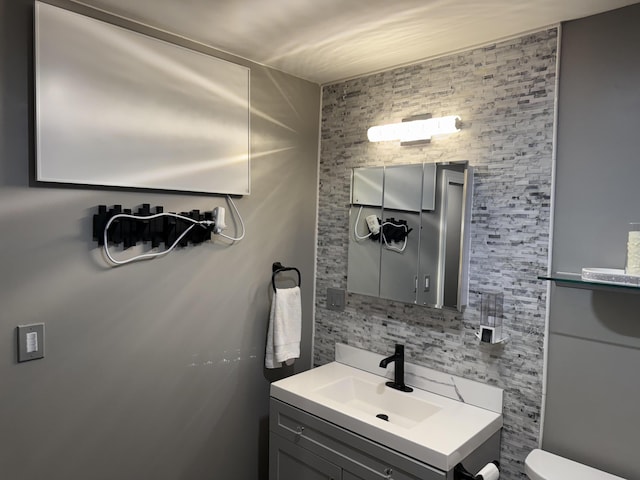 29 Elm St, Fairfield, ME 04937 - half bathroom with vanity, toilet, and tasteful backsplash