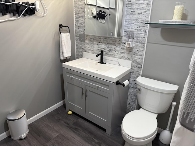29 Elm St, Fairfield, ME 04937 - bathroom featuring wood finished floors, vanity, toilet, baseboards, and backsplash