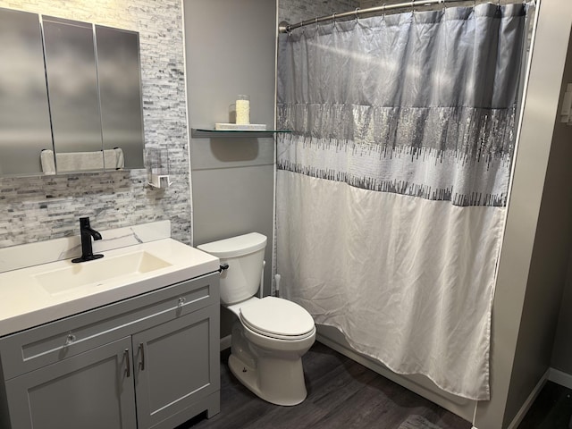 29 Elm St, Fairfield, ME 04937 - bathroom with wood finished floors, toilet, vanity, and tasteful backsplash
