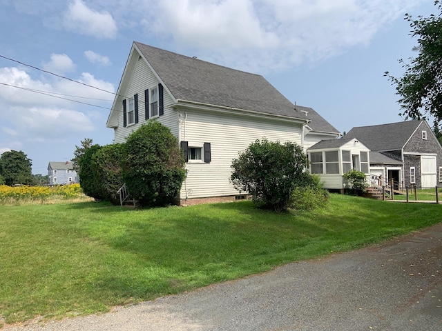 100 Bayside Rd, Ellsworth, ME 04605 - view of side of home featuring a sunroom, roof with shingles, and a yard