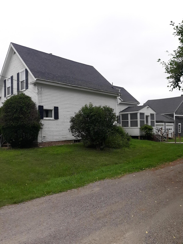 100 Bayside Rd, Ellsworth, ME 04605 - view of side of home featuring a sunroom, roof with shingles, and a lawn