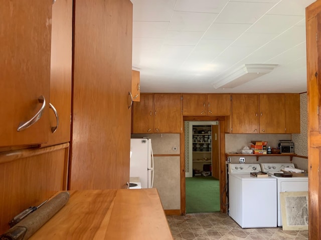 100 Bayside Rd, Ellsworth, ME 04605 - kitchen featuring washer and dryer, brown cabinets, freestanding refrigerator, and light countertops