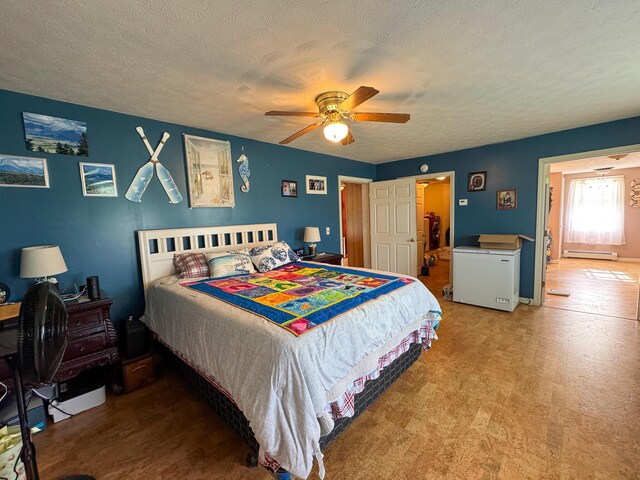 164 Mud Pond Road, Prentiss Twp T7 R3 Nbpp, ME 04487 - bedroom with a baseboard heating unit, a textured ceiling, and a ceiling fan