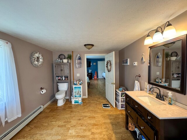 164 Mud Pond Road, Prentiss Twp T7 R3 Nbpp, ME 04487 - bathroom with baseboard heating, toilet, vanity, and a textured ceiling