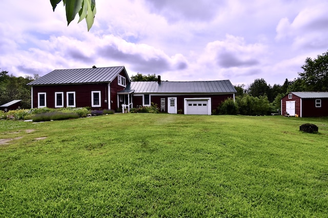 10 Rines Rd, Burnham, ME 04922 - view of front of home with an attached garage, a front yard, a standing seam roof, metal roof, and a storage unit