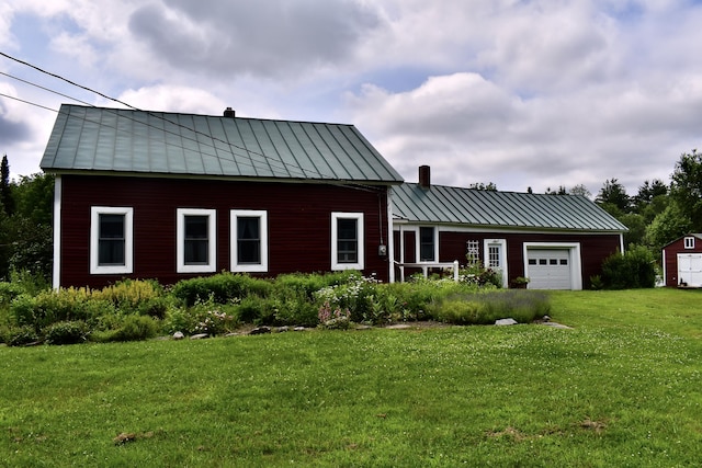 10 Rines Rd, Burnham, ME 04922 - view of front of home with a standing seam roof, an attached garage, a chimney, and a front yard