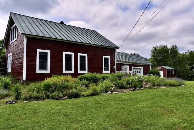 10 Rines Rd, Burnham, ME 04922 - view of side of home featuring a standing seam roof, a yard, and metal roof