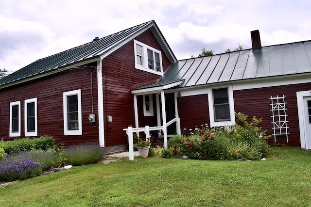 10 Rines Rd, Burnham, ME 04922 - back of house featuring a standing seam roof, a chimney, metal roof, and a lawn