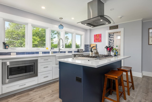 116 Hills Beach Rd, Biddeford, ME 04005 - kitchen with stainless steel appliances, island range hood, white cabinetry, a kitchen island, and a kitchen breakfast bar