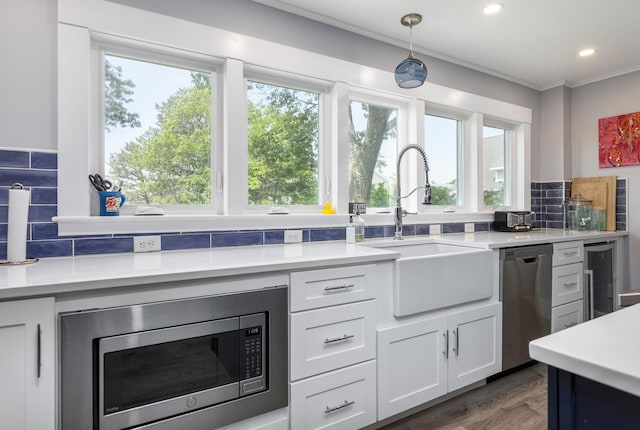 116 Hills Beach Rd, Biddeford, ME 04005 - kitchen with stainless steel appliances, light countertops, plenty of natural light, backsplash, and crown molding