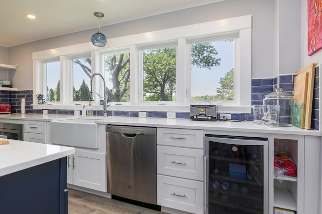 116 Hills Beach Rd, Biddeford, ME 04005 - kitchen with dishwasher, wine cooler, decorative backsplash, light countertops, and ornamental molding