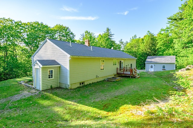 739 Spec Pond Rd, Porter, ME 04068 - rear view of property featuring a lawn, a chimney, a deck, a shingled roof, and an outbuilding
