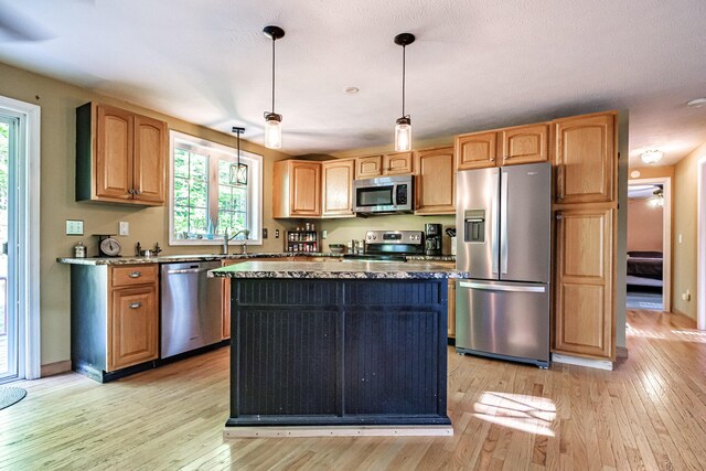 739 Spec Pond Rd, Porter, ME 04068 - kitchen featuring stainless steel appliances, light wood-type flooring, a center island, hanging light fixtures, and a sink