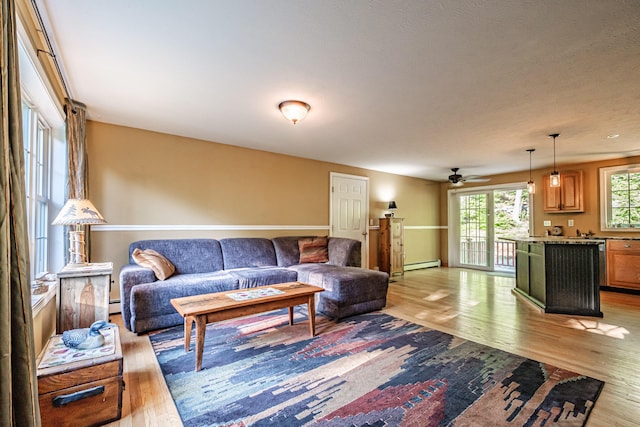 739 Spec Pond Rd, Porter, ME 04068 - living room with light wood finished floors, baseboard heating, and a ceiling fan