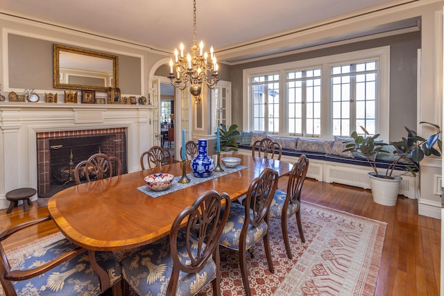 18 Bayside Dr, Belfast, ME 04915 - dining room with hardwood / wood-style floors, a brick fireplace, arched walkways, and a chandelier