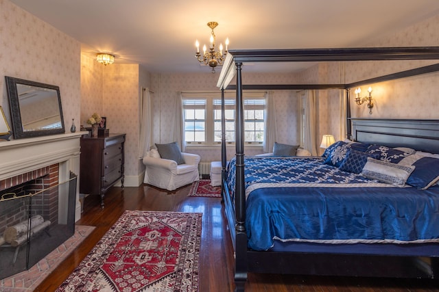 18 Bayside Dr, Belfast, ME 04915 - bedroom with wallpapered walls, a chandelier, hardwood / wood-style floors, and a brick fireplace