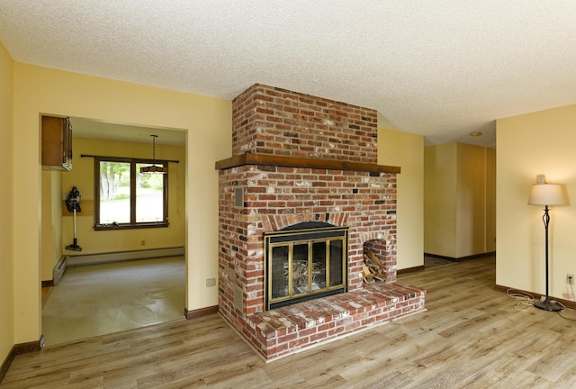 56 Borland Hill Rd, Nobleboro, ME 04555 - unfurnished living room with baseboard heating, a textured ceiling, wood finished floors, and a brick fireplace