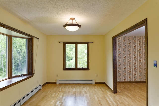 56 Borland Hill Rd, Nobleboro, ME 04555 - empty room featuring a baseboard heating unit, light wood-style flooring, and a textured ceiling