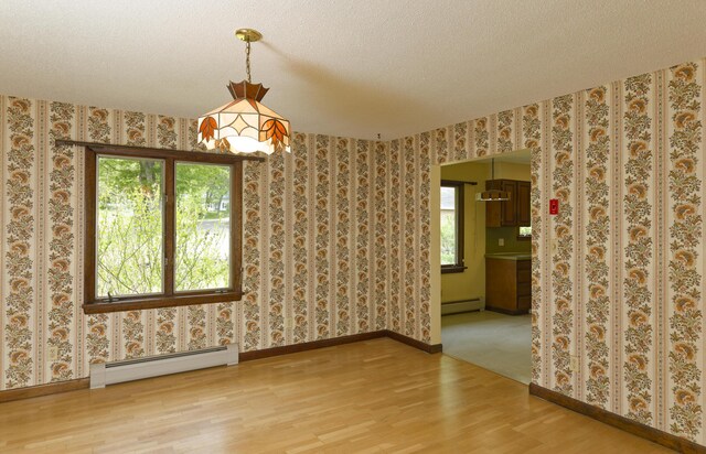 56 Borland Hill Rd, Nobleboro, ME 04555 - spare room with a baseboard radiator, wood finished floors, wallpapered walls, and a textured ceiling