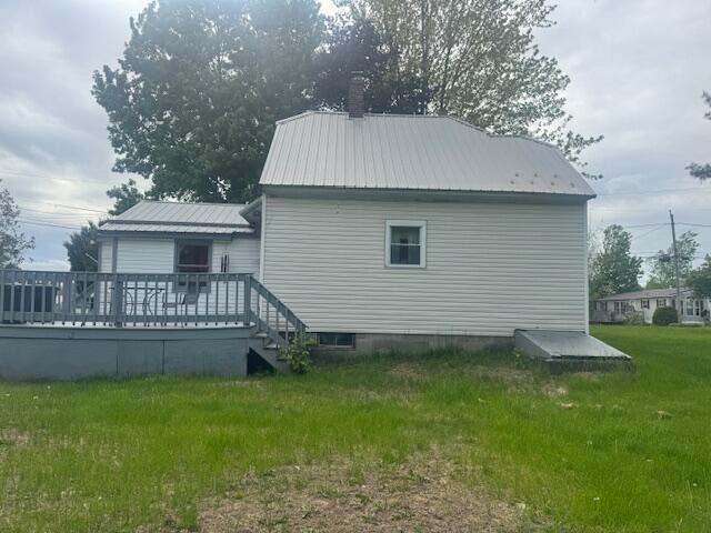 179 Raymond St, Pittsfield, ME 04967 - view of side of property featuring a wooden deck, a lawn, and metal roof