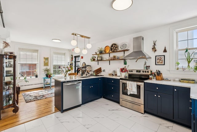 148 State St, Portland, ME 04101 - kitchen featuring wall chimney exhaust hood, appliances with stainless steel finishes, blue cabinetry, a peninsula, and light countertops
