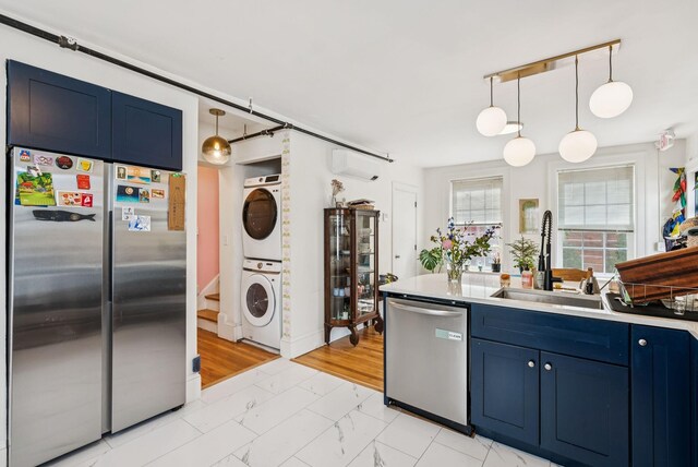 148 State St, Portland, ME 04101 - kitchen featuring stainless steel appliances, stacked washer / drying machine, blue cabinetry, and light marble finish flooring