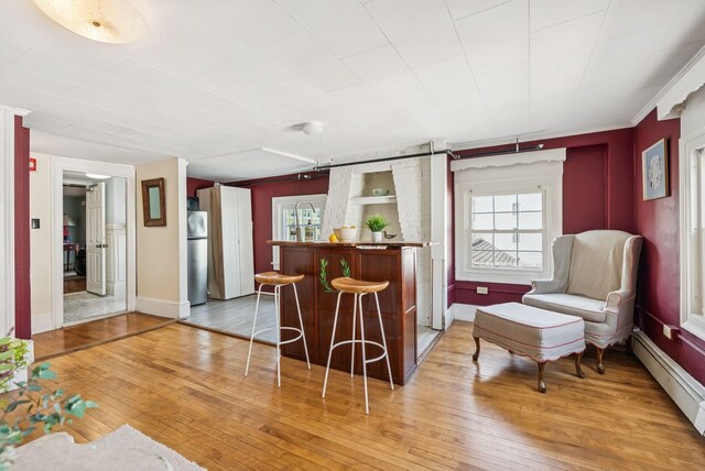 148 State St, Portland, ME 04101 - bar area featuring freestanding refrigerator, light wood finished floors, a baseboard radiator, and baseboards