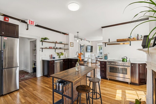 148 State St, Portland, ME 04101 - kitchen with stainless steel appliances, open shelves, light wood-style floors, and dark brown cabinets