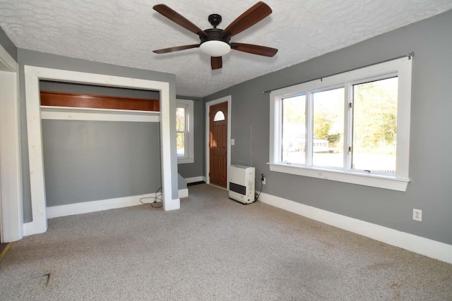 50 Baldwin Rd, Sebago, ME 04029 - unfurnished bedroom featuring heating unit, a textured ceiling, carpet floors, baseboards, and a closet