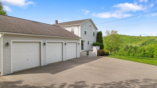 216 Monroe Rd, Winterport, ME 04496 - view of side of home with a chimney, a shingled roof, and driveway