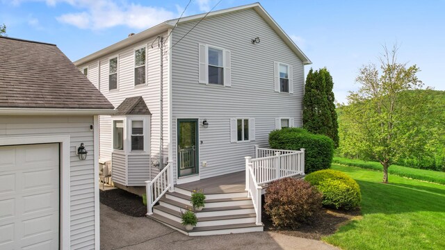 216 Monroe Rd, Winterport, ME 04496 - view of front of home with a garage, a front yard, a wooden deck, and a shingled roof