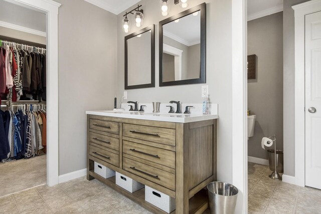 216 Monroe Rd, Winterport, ME 04496 - full bathroom with double vanity, crown molding, a spacious closet, baseboards, and toilet